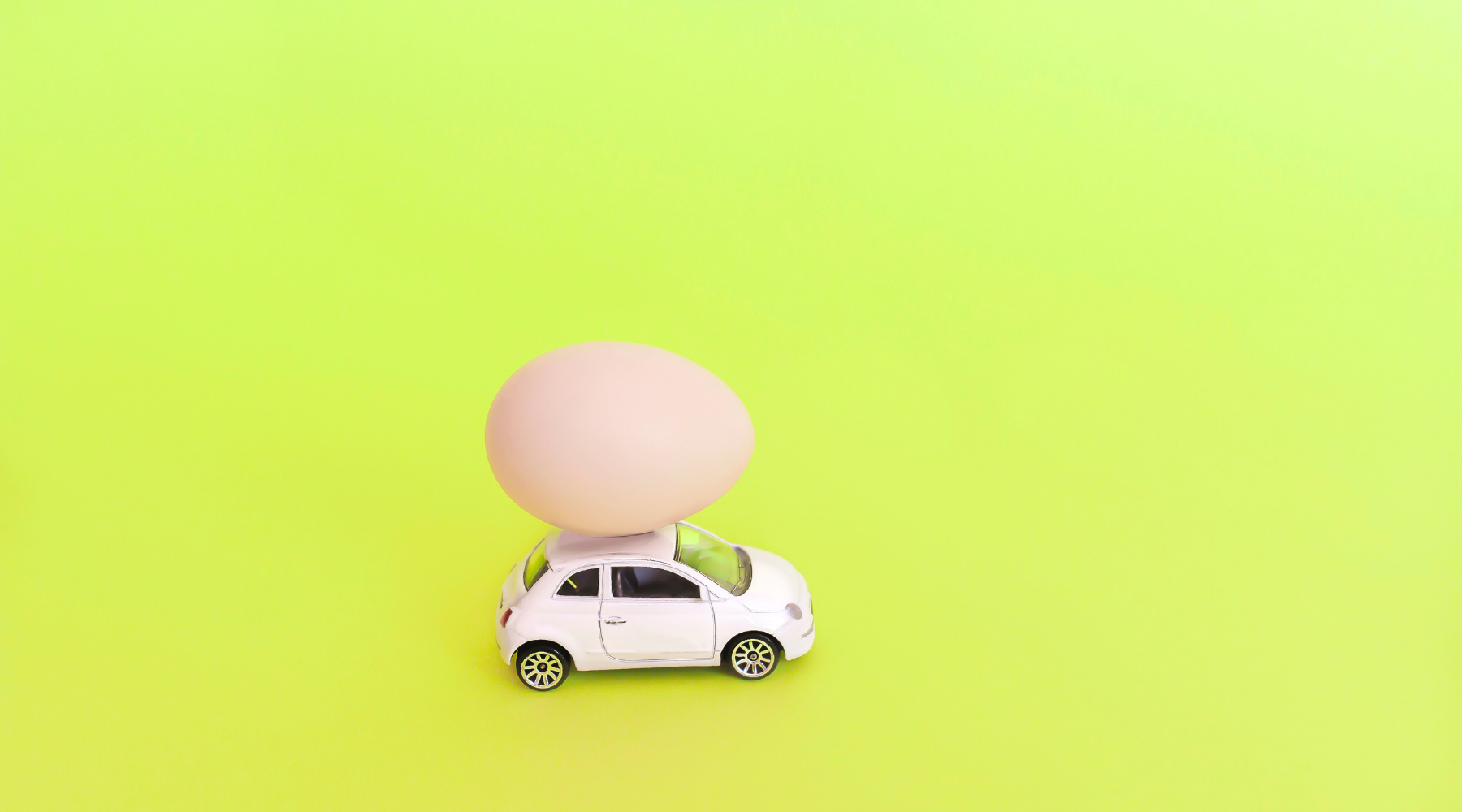 egg balanced on a toy car
