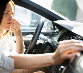 female experiencing bad smells in car