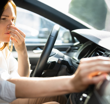 female experiencing bad smells in car