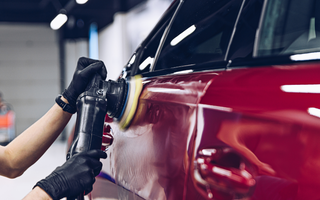 Professional demonstrating swirl removal technique on car paint