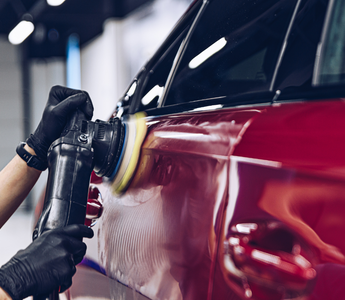 Professional demonstrating swirl removal technique on car paint