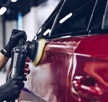 Professional demonstrating swirl removal technique on car paint