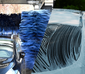Car being washed with a foam lance vs an automatic car wash tunnel