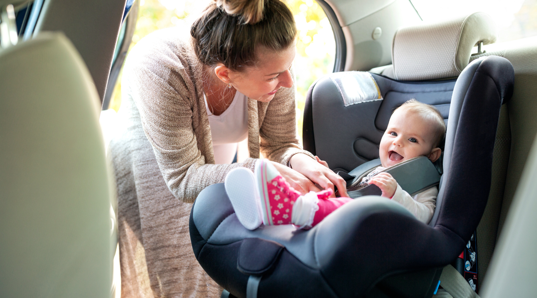 parents strapping child into a clean car seat